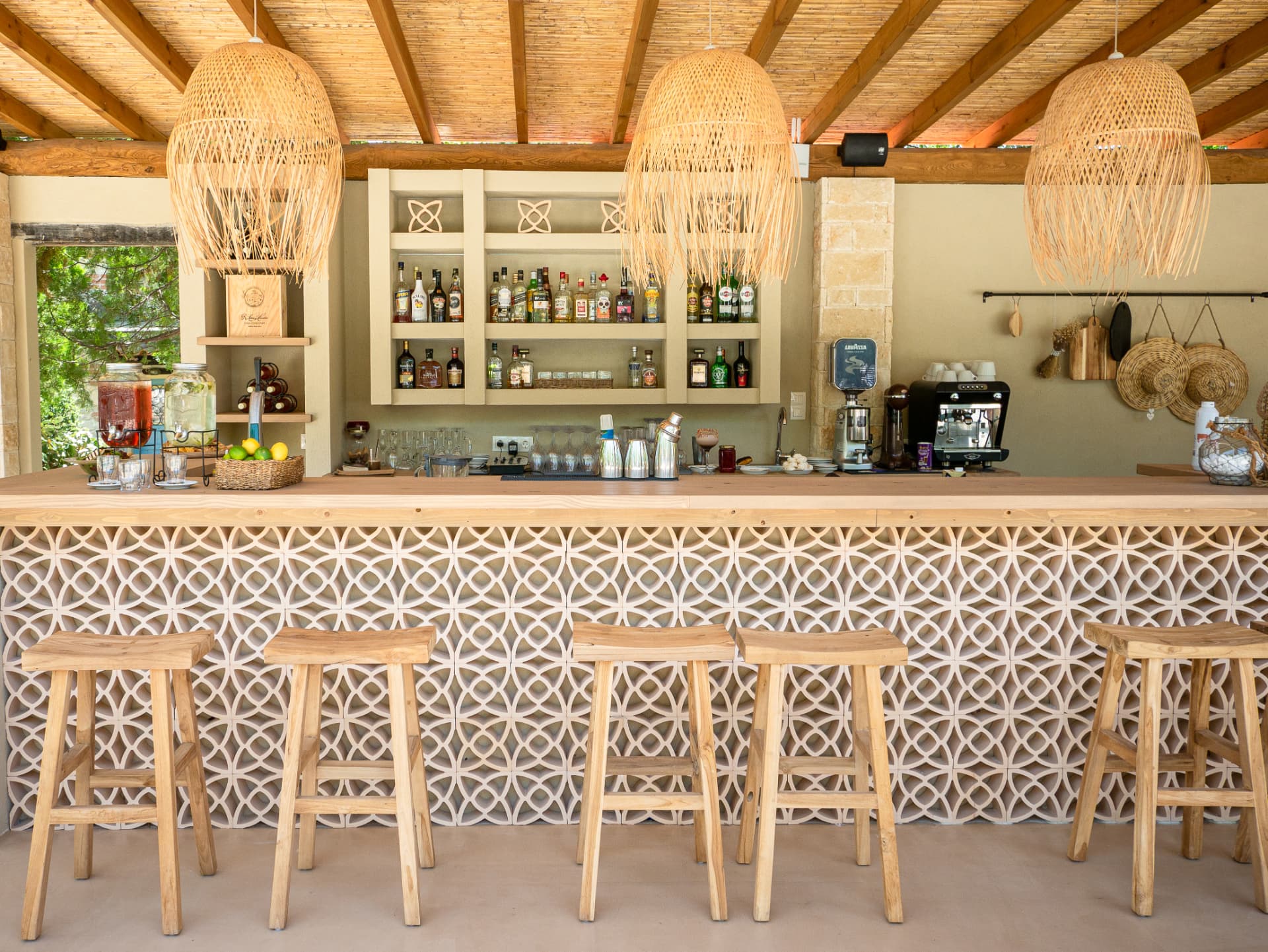 Το pool bar με πλεκτά φωτιστικά και ξύλινα σκαμπό