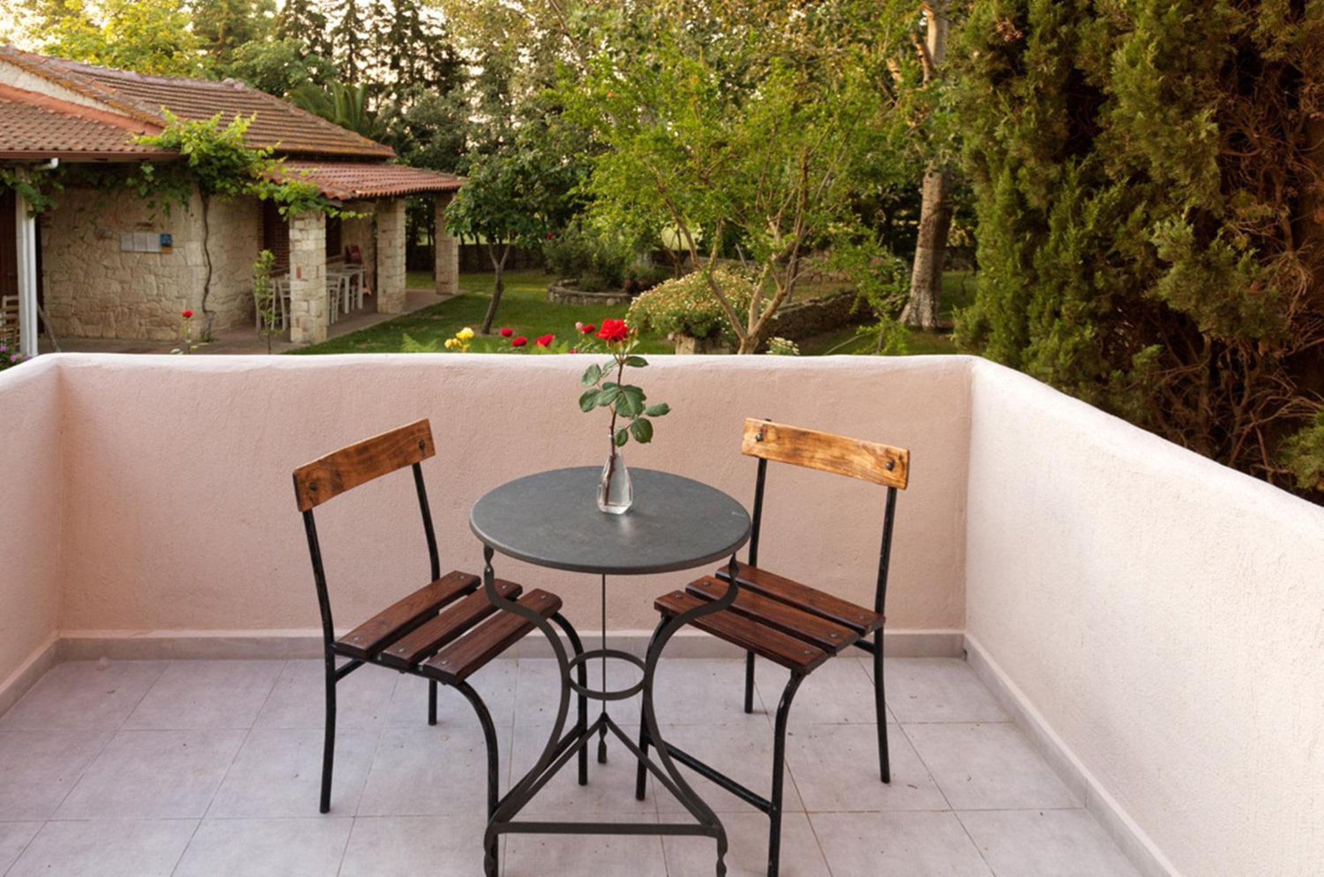 Private balcony with bistro table overlooking the gardens.