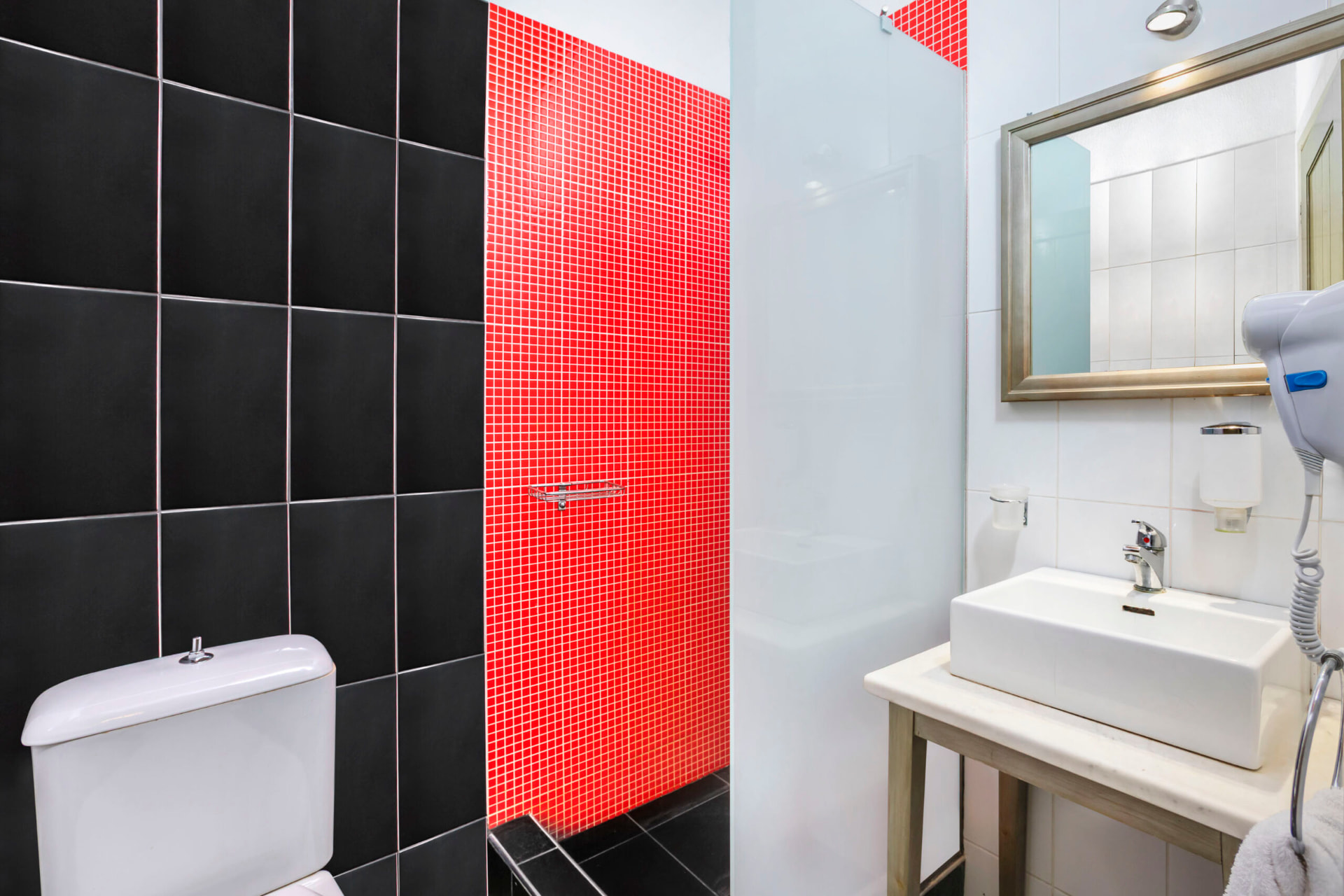 Bathroom with walk-in shower and mosaic detail.