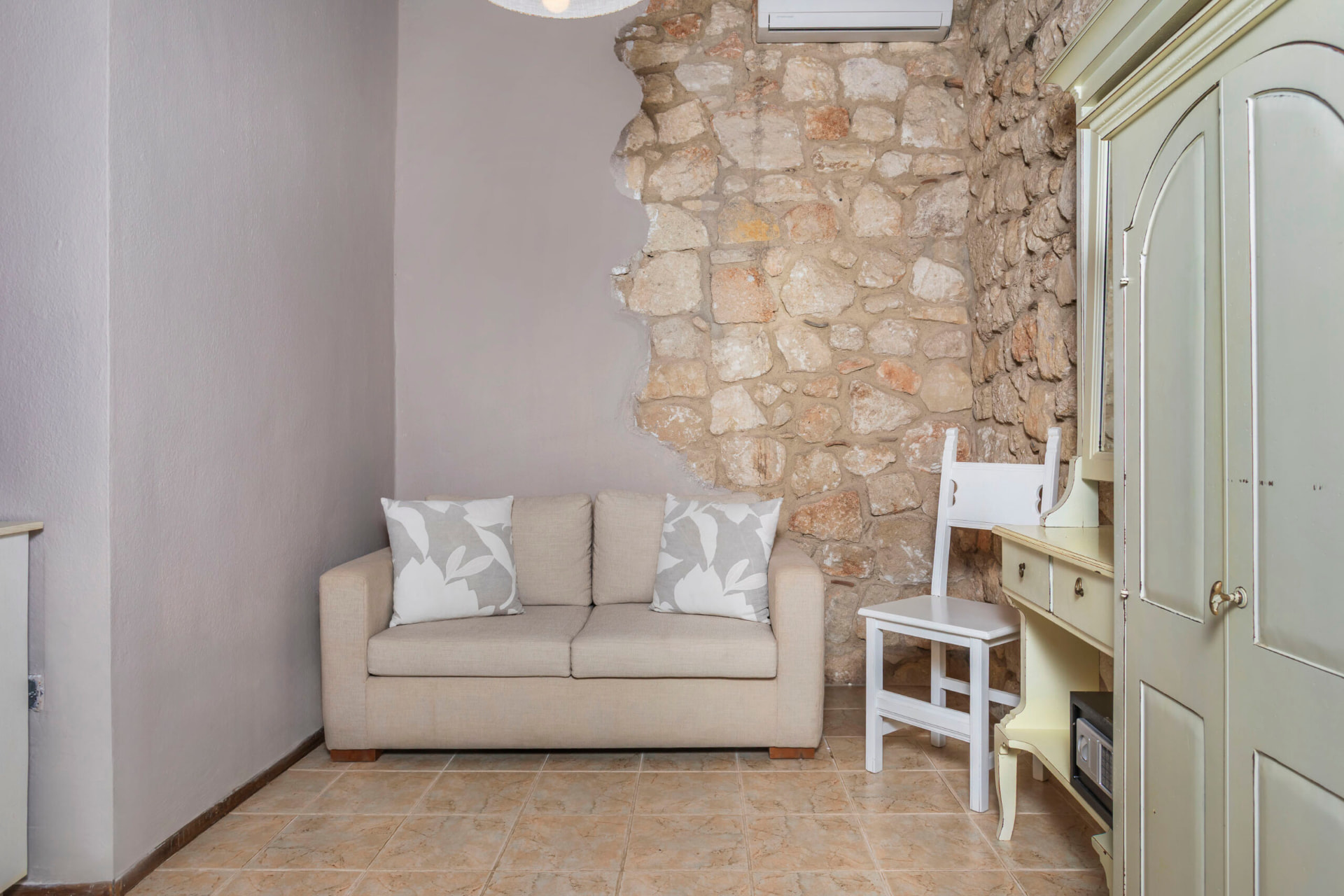 Sofa against the exposed stone wall.