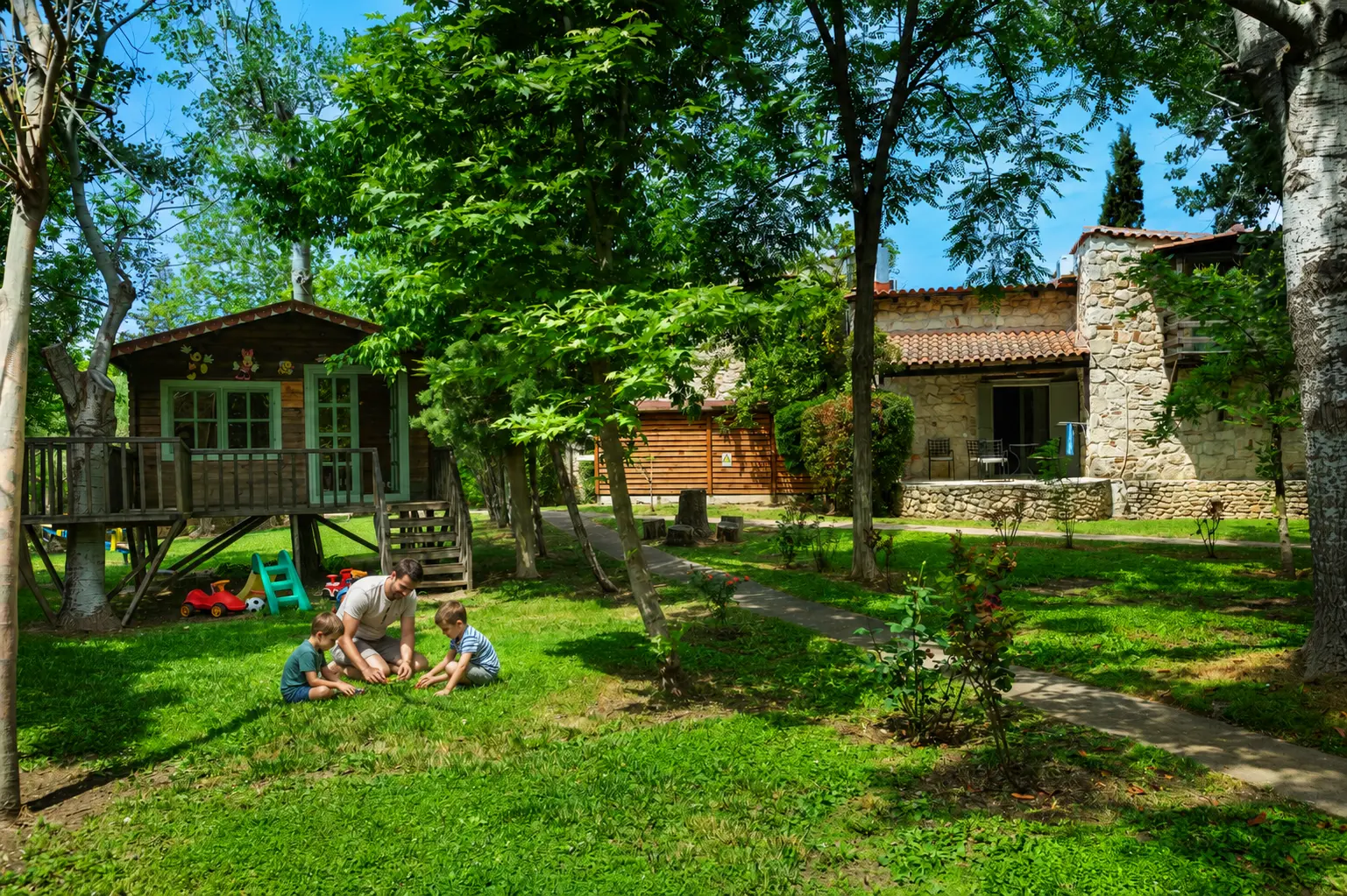 The treehouse and stone houses among the village gardens.