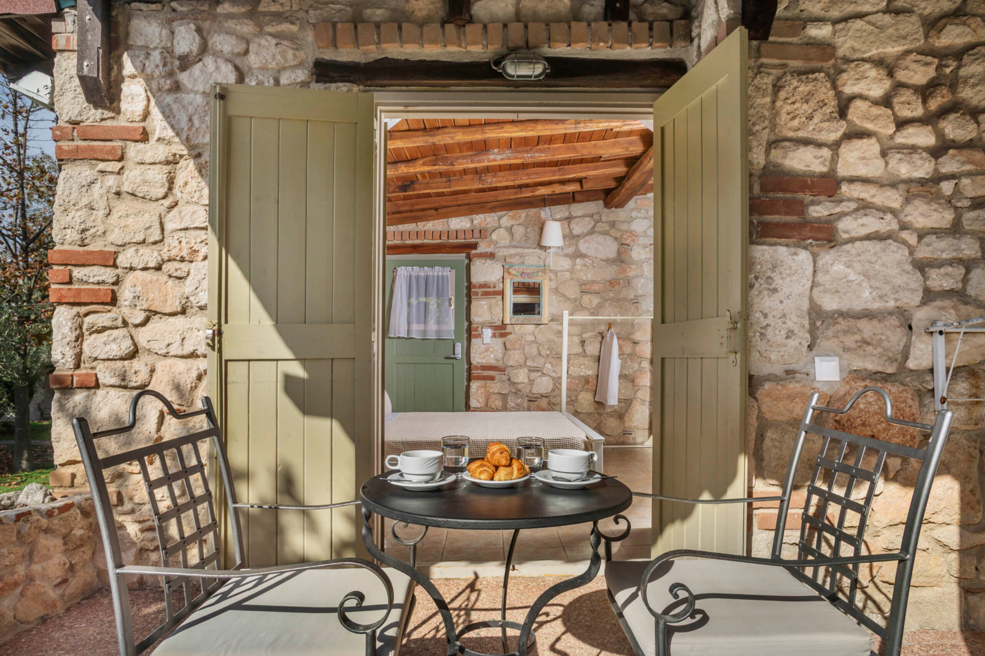 Private veranda with breakfast table by the open doors.