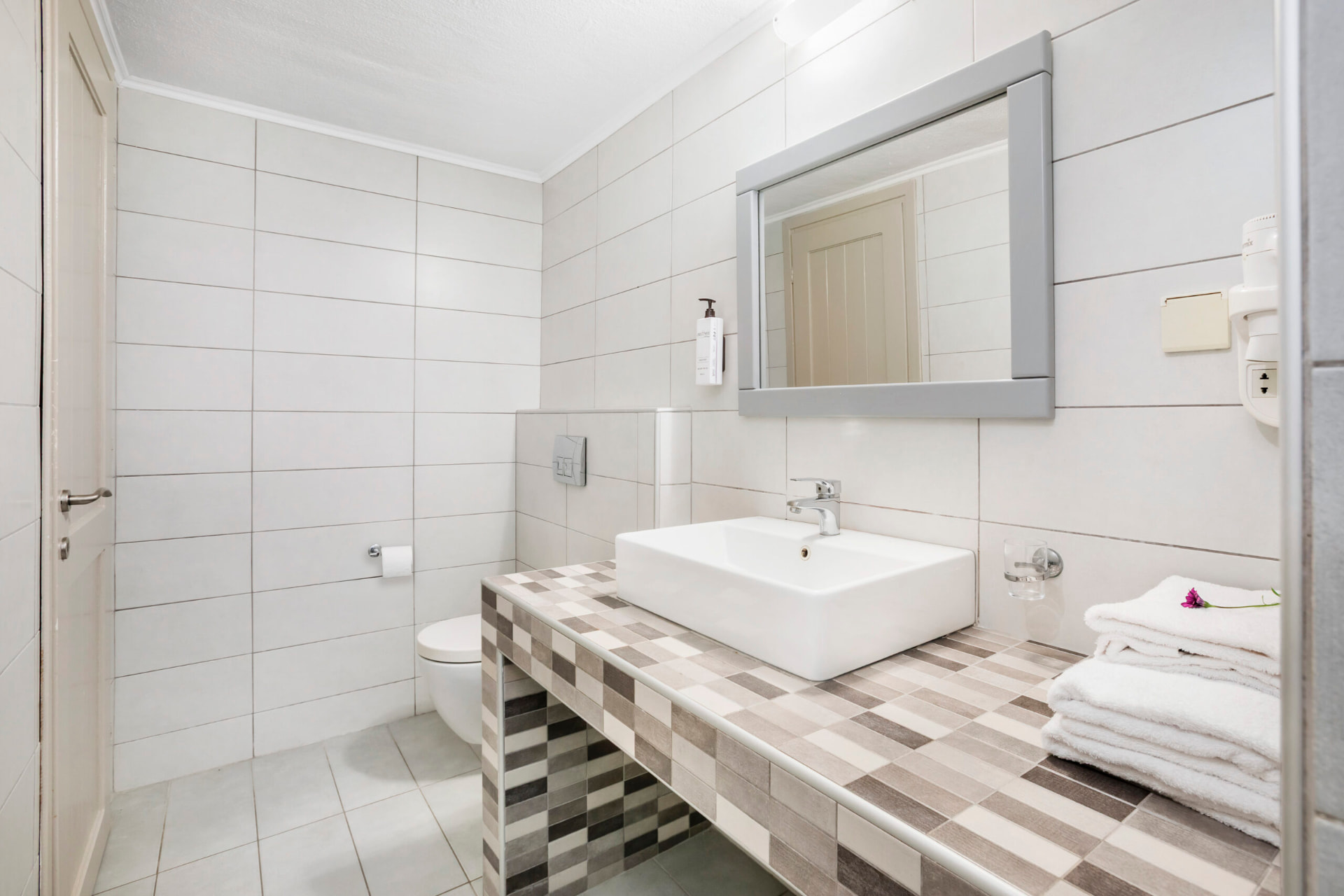Bathroom with mosaic vanity and walk-in shower.