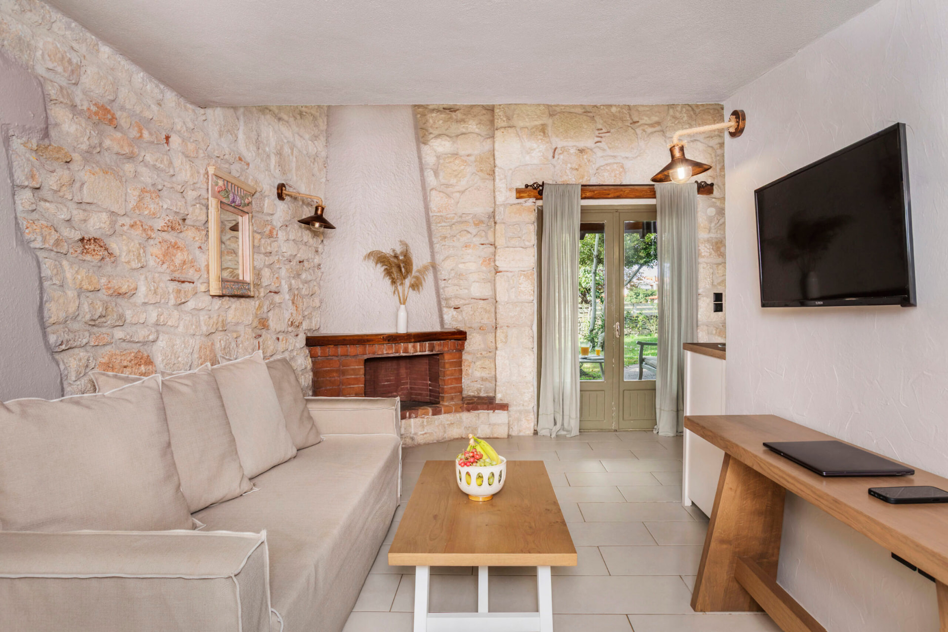Living room with sofa, brick fireplace and garden door.